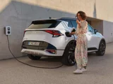 Kia Sportage wit schuinachter Thuis Opladen met vrouw ernaast