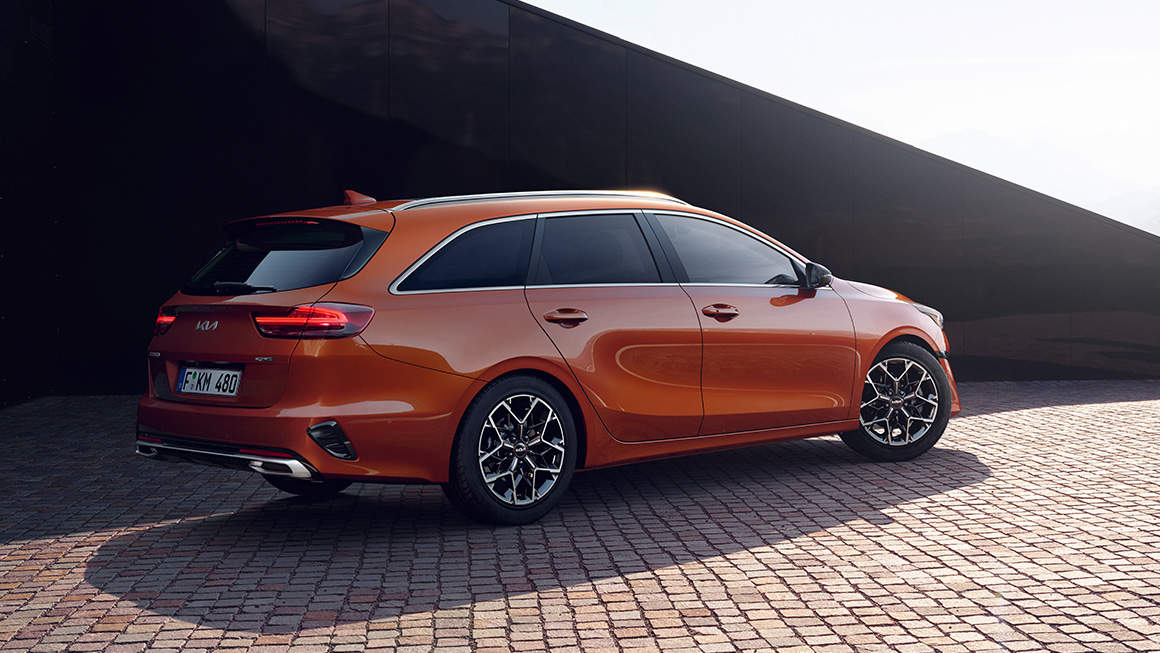 Oranje Kia Ceed Sportswagon achterkant en zijkant geparkeerd